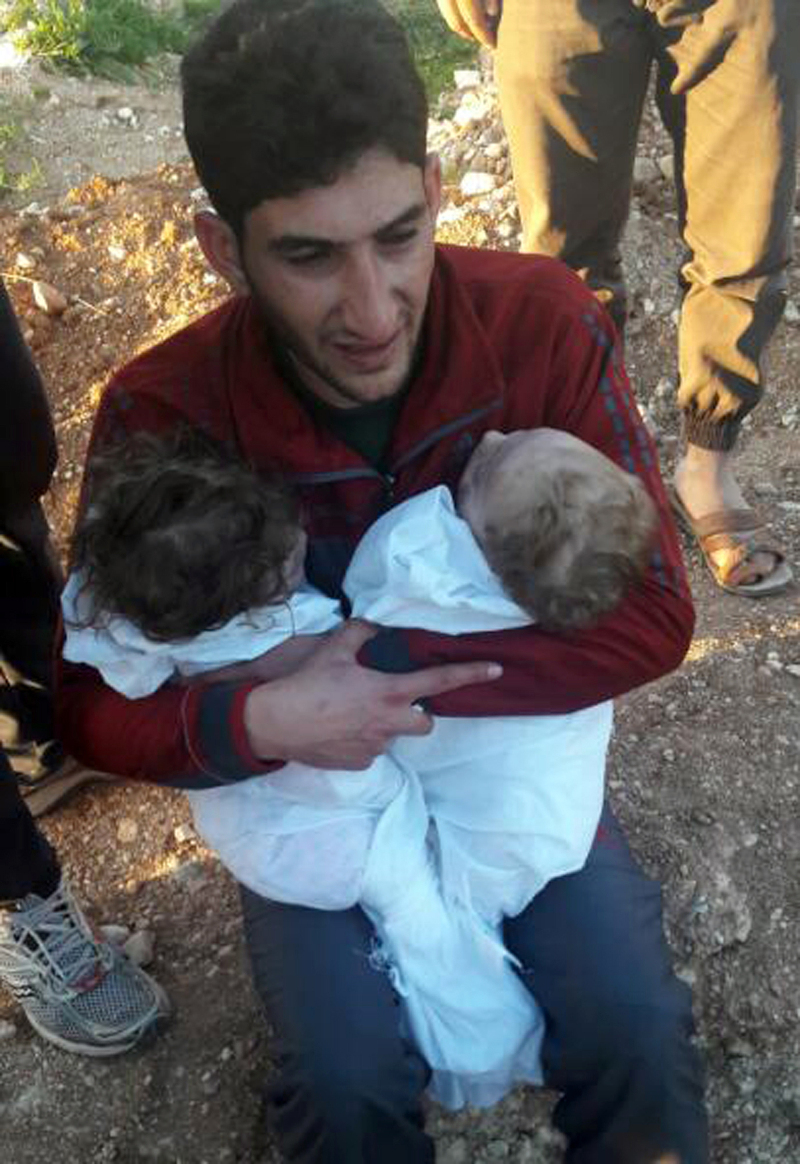 H φωτογραφία που συγκλονίζει: Συντετριμμένος πατέρας αγκαλιάζει τα νεκρά δίδυμά του μετά την επίθεση με χημικά στη Συρία (εικόνες)